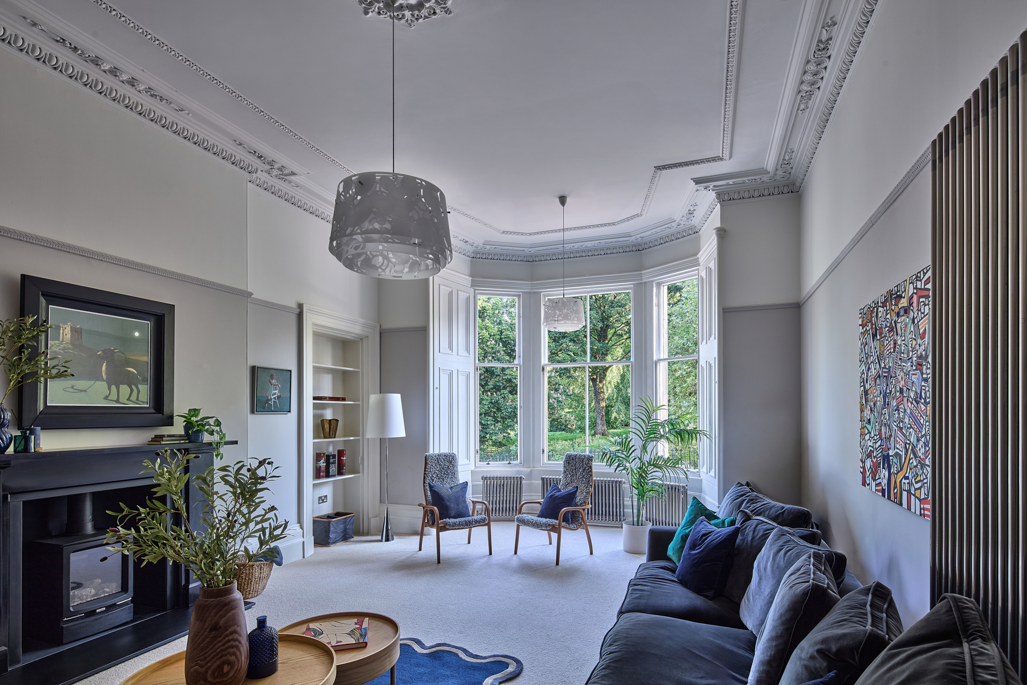 Bay-windowed living room with restored cornicing and a pendant light