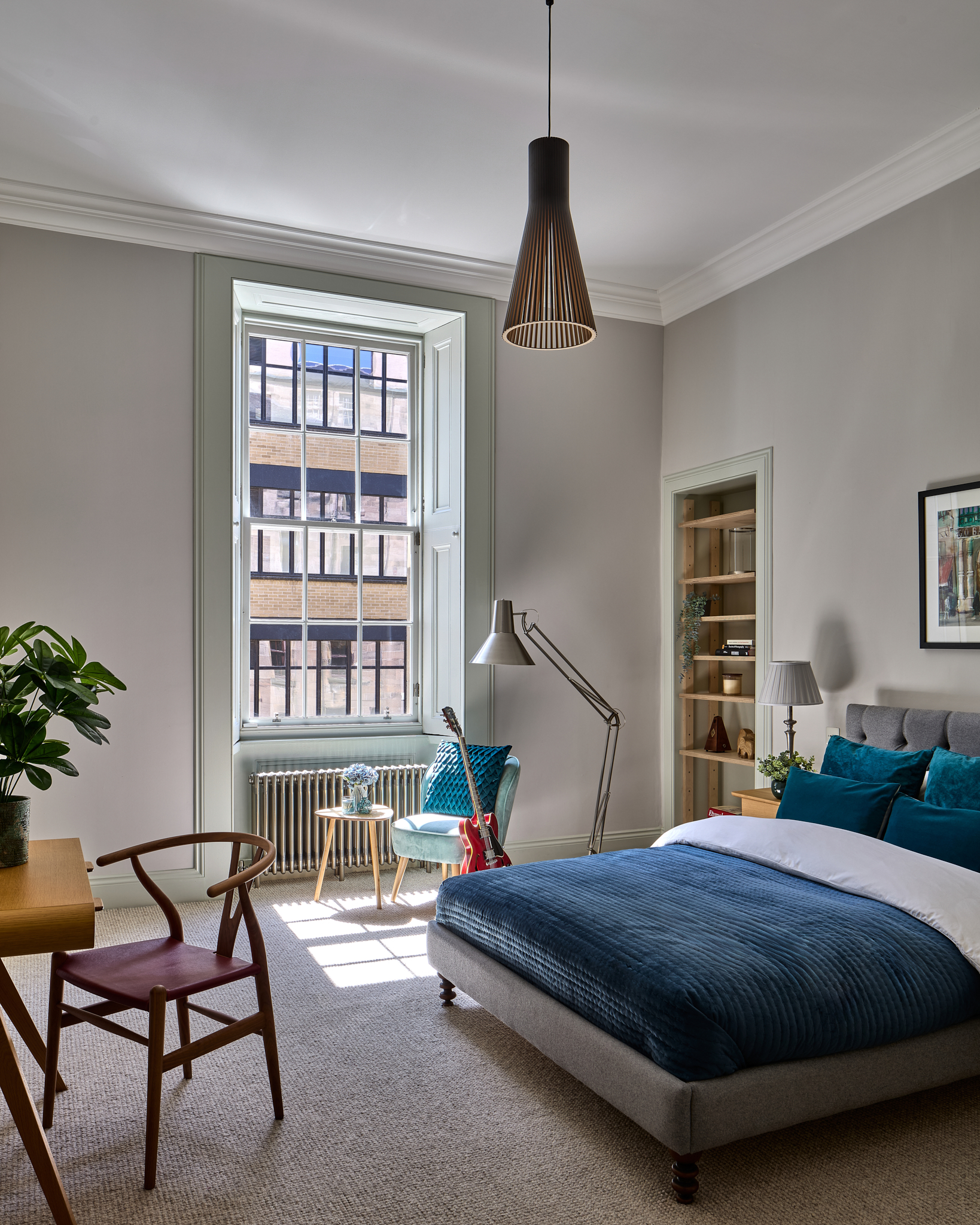 Bedroom with fitted shelving beside the window