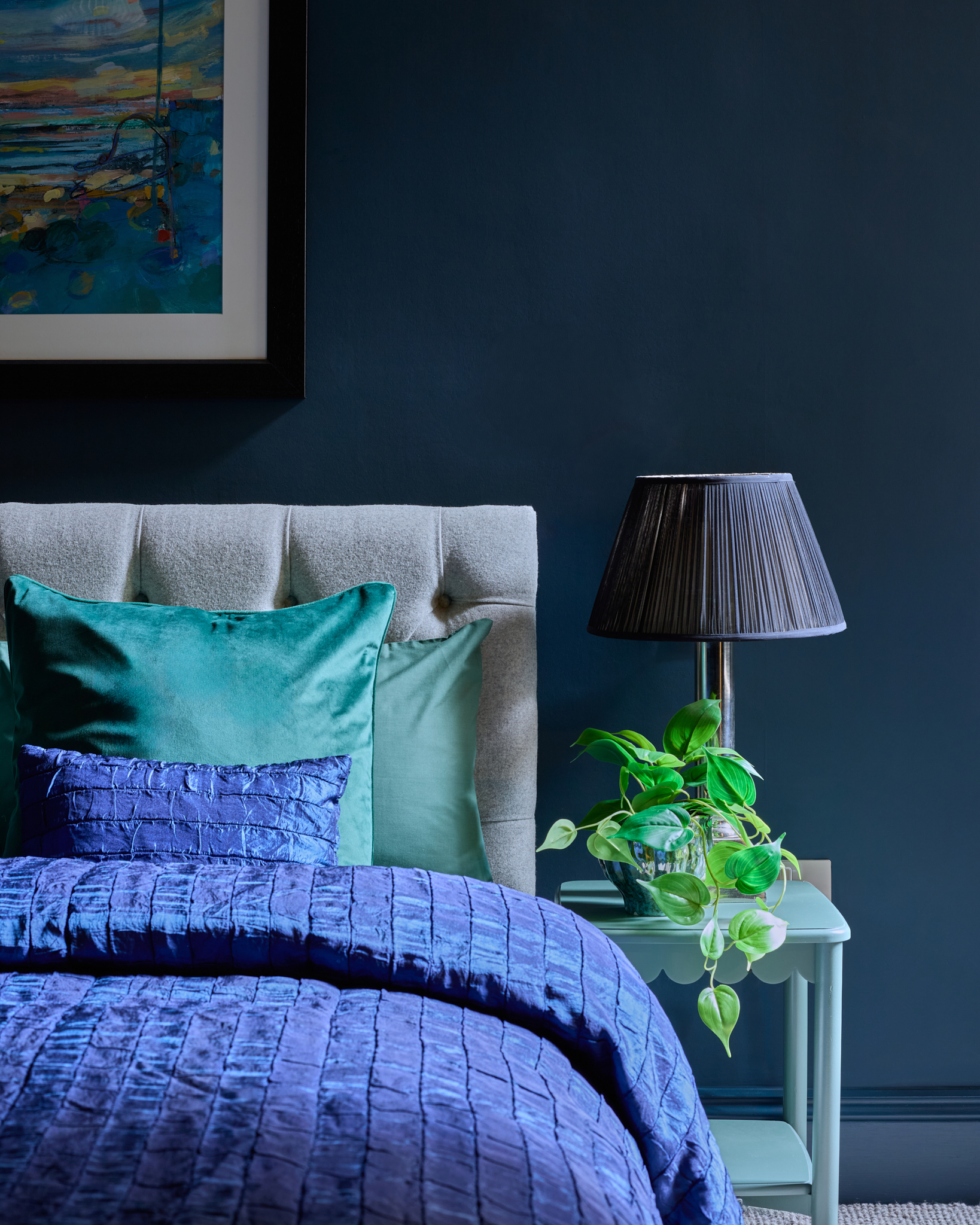 Bedroom with a deep navy wall behind the bed