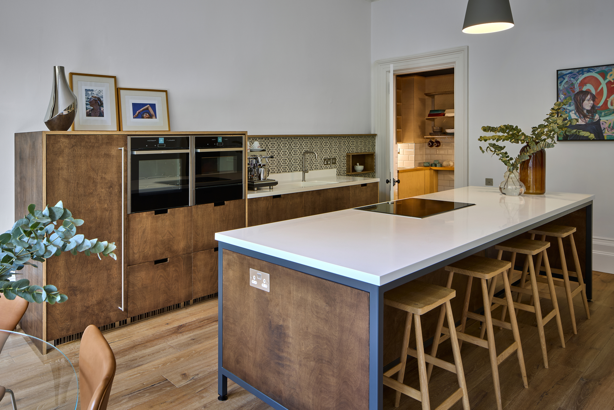 Kitchen island with white worktop and integrated ovens